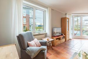 Stadtlust 2 في هوسوم: غرفة معيشة مع كرسي وتلفزيون