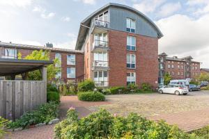 Stadtlust 2 في هوسوم: مبنى كبير من الطوب مع سيارة متوقفة في موقف للسيارات