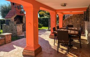 eine orangefarbene Veranda mit Tisch und Stühlen auf einer Terrasse in der Unterkunft Beautiful Apartment In Opric With Wifi in Ika