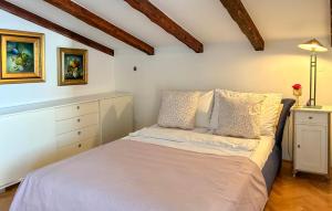 Schlafzimmer mit einem Bett mit weißer Bettwäsche und einer Kommode in der Unterkunft Beautiful Apartment In Opric With Wifi in Ika