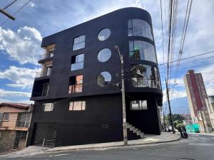 a black building with circular windows on the side of it at Moore 45 Tu Espacio Comodo en Medellín in Medellín