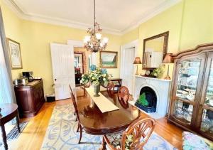 a dining room with a table and chairs and a fireplace at Magnolia Suite- The Belvedere Inn in Oswego