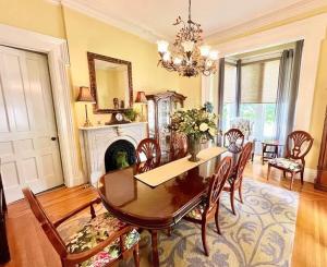 a dining room with a table and chairs and a fireplace at Magnolia Suite- The Belvedere Inn in Oswego