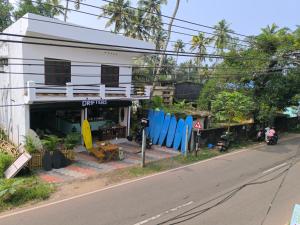 a building with surfboards on the side of the street at The Arena Edava in Paravūr