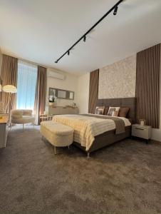 a large bedroom with a large bed and a chair at SpaNish FoROOM 1 in Niš
