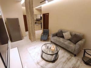 un soggiorno con un divano e un tavolo di vetro di Ram101 a Gedda