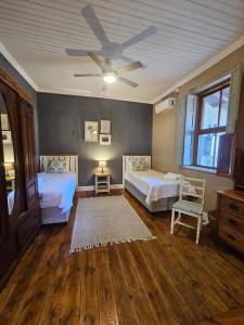 a bedroom with two beds and a ceiling fan at The Homestead at Koringberg Country Cottages in Koringberg