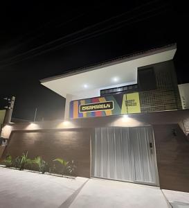a building with a sign above a garage at Studios Casamarela in Mossoró