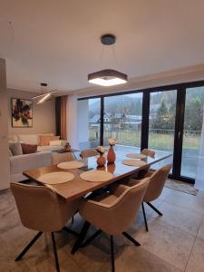 a dining room with a wooden table and chairs at Kasztanowy Zakątek in Szczyrk