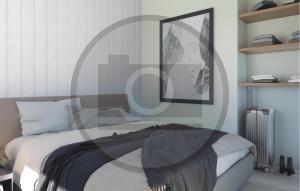 HasmarkNice Home In Otterup With Sauna的卧室里有一张床，墙上挂着一幅画 更多11张照片