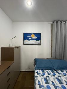 a bedroom with a bed and a picture on the wall at Studios Casamarela in Mossoró