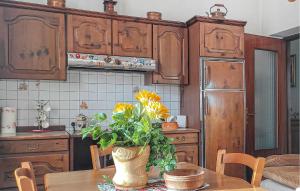 a kitchen with a table with a vase of flowers on it at Lovely Home In Caranzavarese Ligure in Groppo