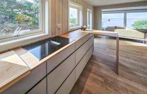 una cocina con una gran isla con encimera de cristal en Amazing Home In Gressvik With Wifi, en Slevik