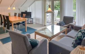 4 Bedroom Gorgeous Home In Tranekær في Stoense: غرفة معيشة مع أريكة وطاولة وكراسي