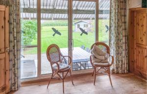 4 Bedroom Gorgeous Home In Tranekær في Stoense: كرسيان يجلسون أمام النافذة