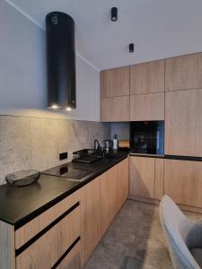 a kitchen with wooden cabinets and a black counter top at Kasztanowy Zakątek in Szczyrk
