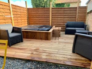 un patio con due sedie e un letto su un ponte di legno di Spa Wifi Canal Plus a Rouillé