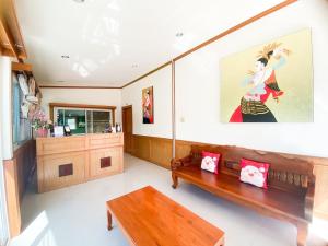 a living room with a bench and a painting on the wall at Na Soi 5 Chiangkhan in Chiang Khan