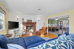 a living room with a blue couch and a fireplace at 350 School House Road Eastham - Beach Dreams in Eastham