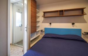 Lovely Home In Tarquinia With Swimming Pool في Porto Clementino: غرفة نوم بسرير ازرق وباب زجاجي