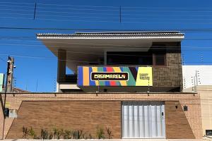 a building with a sign on top of it at Studio Caju - 3 min do Mossoró Cidade Junina in Mossoró