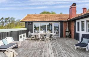 a wooden deck with a table and chairs on it at 5 Bedroom Cozy Home In Onsala in Draget