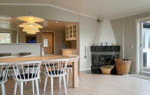 a kitchen with a wooden table and a fireplace at 5 Bedroom Cozy Home In Onsala in Draget