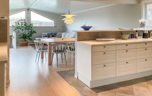 a kitchen with a counter and a table with chairs at 5 Bedroom Cozy Home In Onsala in Draget