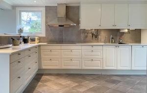 a white kitchen with white cabinets and a window at 5 Bedroom Cozy Home In Onsala in Draget +21 photos