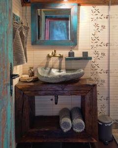 ein Badezimmer mit Waschbecken und Spiegel in der Unterkunft Mountain Cottage Jarilo - Scenic Fruska Gora Retreat with Fireplace, Sauna and Large Private Yard in Ležimir