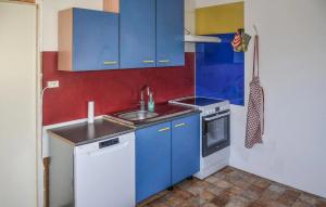 eine kleine Küche mit blauen Schränken und einer Spüle in der Unterkunft 2 Bedroom Nice Home In Virserum in Virserum