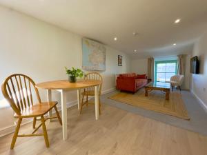 un soggiorno con tavolo, sedie e divano di The Little Egret a Swansea 1 altra foto