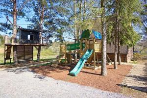ein Spielplatz mit Rutsche und Baumhaus in der Unterkunft Mountain Cottage Jarilo - Scenic Fruska Gora Retreat with Fireplace, Sauna and Large Private Yard in Ležimir
