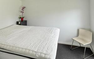 a bedroom with a white bed and a chair at 2 Bedroom Amazing Home In Samsø in Kolby Kås