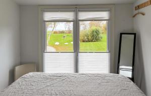 a bedroom with a window with a bed and a mirror at 2 Bedroom Amazing Home In Samsø in Kolby Kås