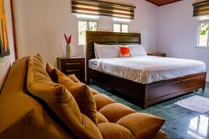 a bedroom with a bed and a couch at Casa de Campo Rio Piedra Farm Portobelo in María Chiquita +21 photos