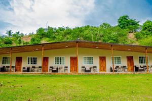 a building with a grass field in front of it at Casa de Campo Rio Piedra Farm Portobelo in María Chiquita