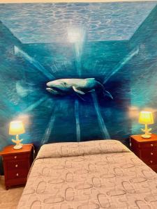 Coralli di Mare - 5 Terre JRE في لا سبيتسيا: غرفة نوم مع لوحة حوت على الحائط