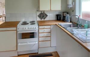 Una cocina con una estufa blanca y un fregadero. en 2 Bedroom Awesome Home In Jönåker, en Stavsjo