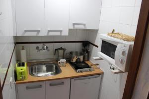 a small kitchen with a sink and a microwave at Triana Historic Center in Seville