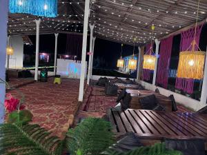 eine Terrasse mit Bänken, Kronleuchtern und Lichtern in der Unterkunft The Secret Sector in Gokarna + 19 Fotos