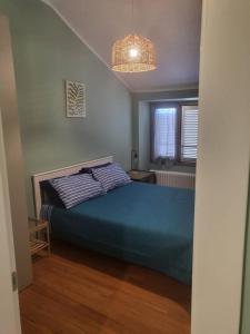 a bedroom with a blue bed and a window at Elegante Suite in Centro Torino · Self Check-in in Turin