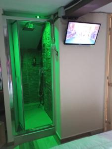 塞拉圣布鲁诺IL Vicoletto的带淋浴的浴室，墙上有一台电视
