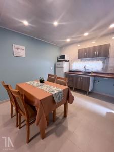 una cucina con tavolo e sedie e una cucina con lavandino di Taruca Apart a Ciudad Evita