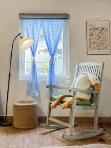 a rocking chair with a stuffed animal in a window at Chái Nho Homestay in Da Lat