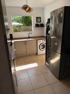 a kitchen with a refrigerator and a washing machine at Villa avec piscine privée à Rivière-Salée - 110 m² in Quartier la Fleury Guiné