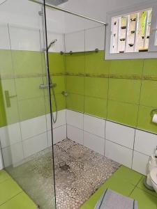 a bathroom with a shower with green and white tiles at Villa avec piscine privée à Rivière-Salée - 110 m² in Quartier la Fleury Guiné
