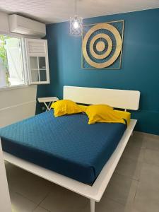 a blue bedroom with a bed with yellow pillows at Villa avec piscine privée à Rivière-Salée - 110 m² in Quartier la Fleury Guiné