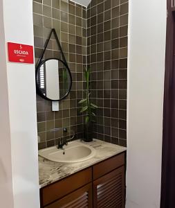 a bathroom with a sink and a mirror at Studios Casamarela in Mossoró