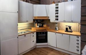 a white kitchen with white cabinets and a sink at 4 Bedroom Pet Friendly Home In Svingvoll in Aulstad